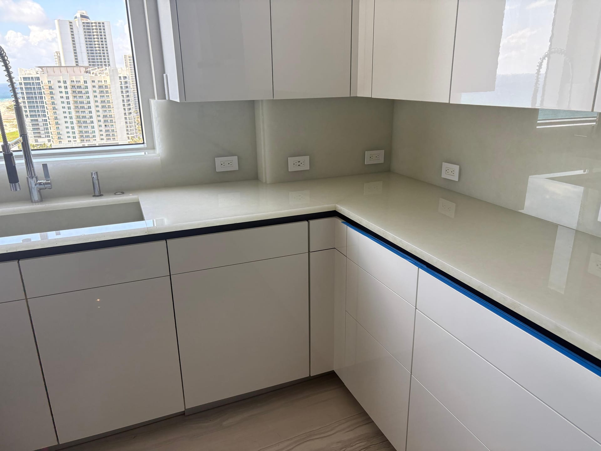 L-shaped white quartz kitchen with skyline views