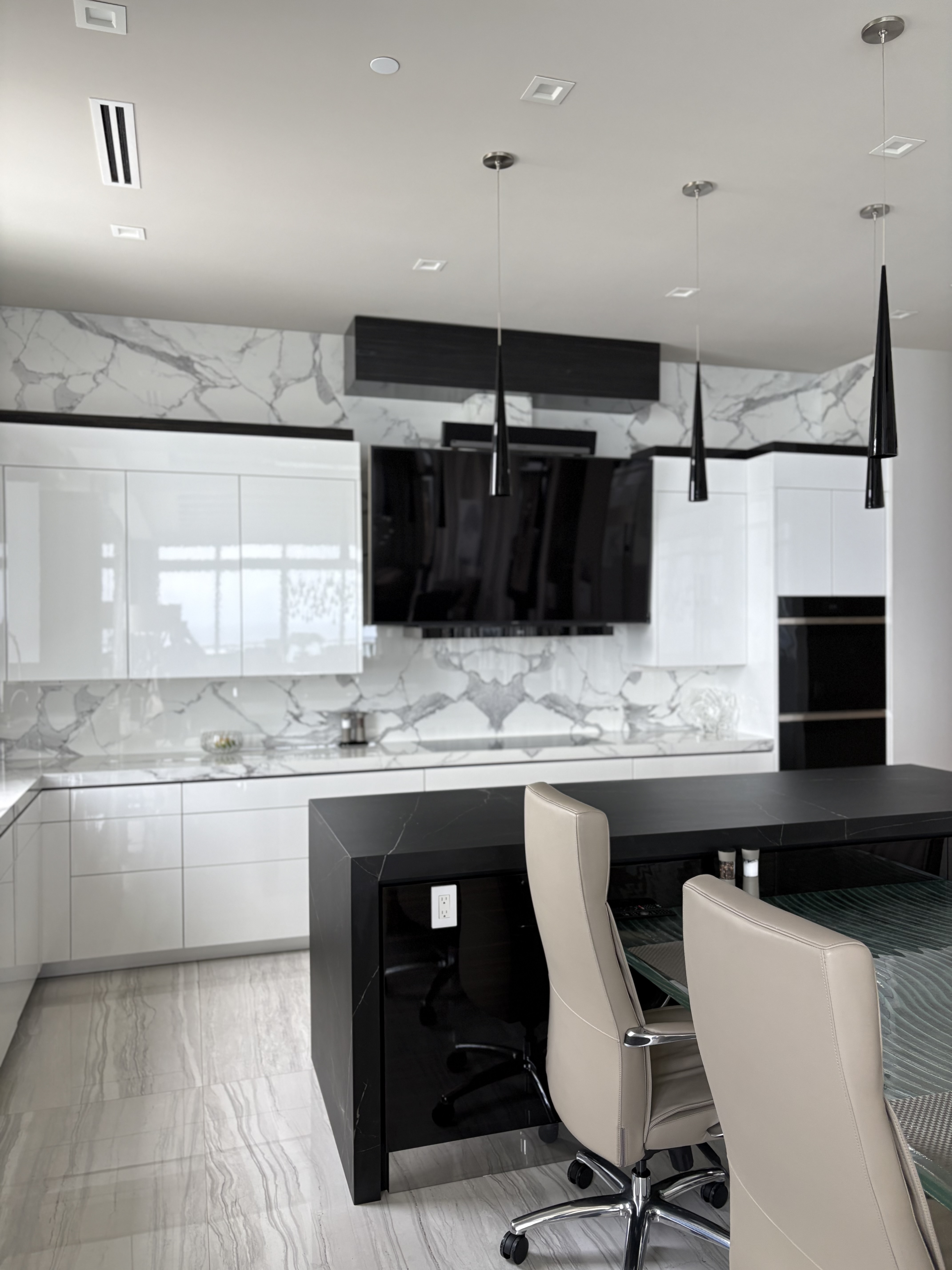 Full-height marble backsplash with a black waterfall island