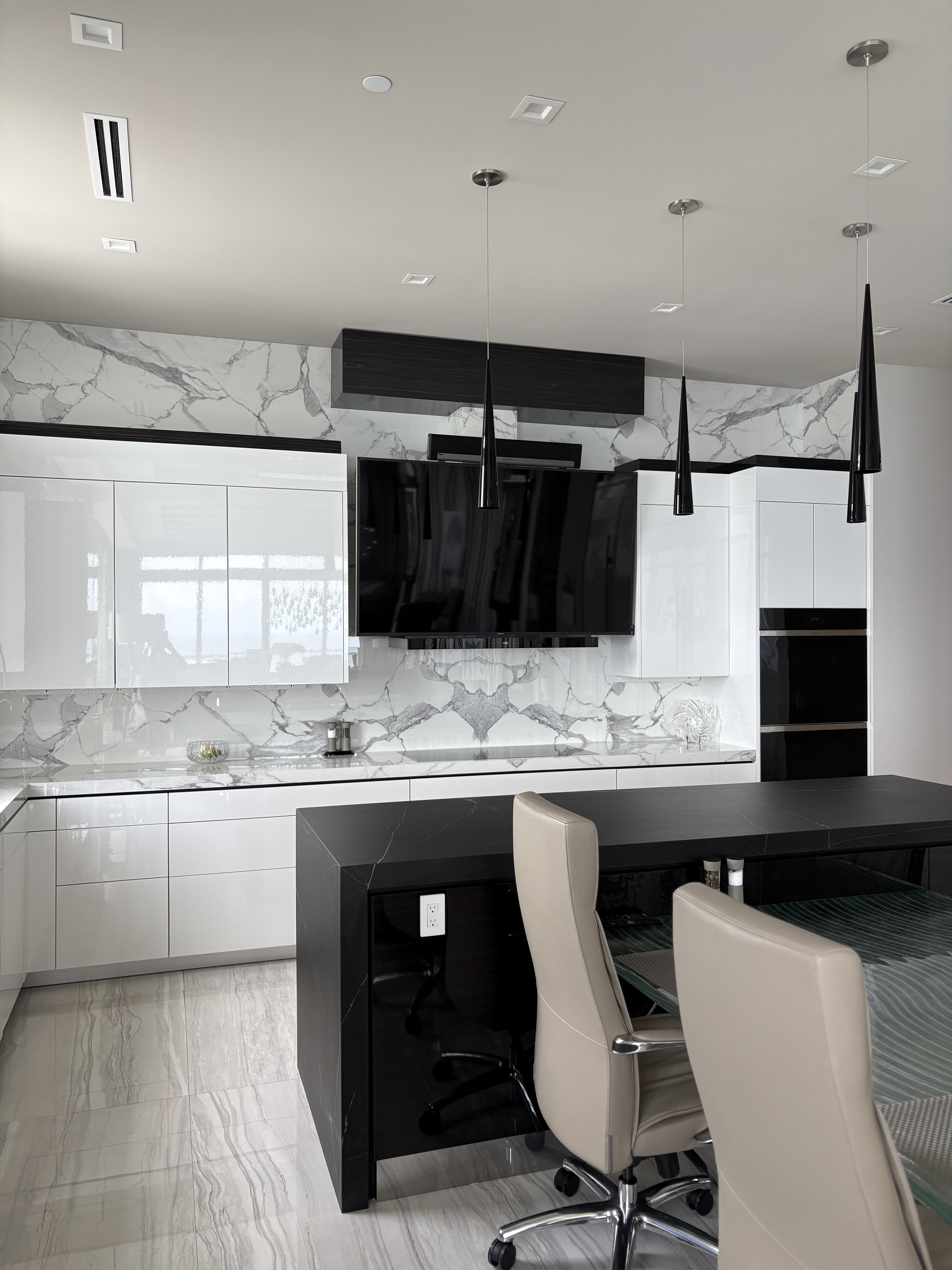 L-shaped white quartz kitchen with skyline views