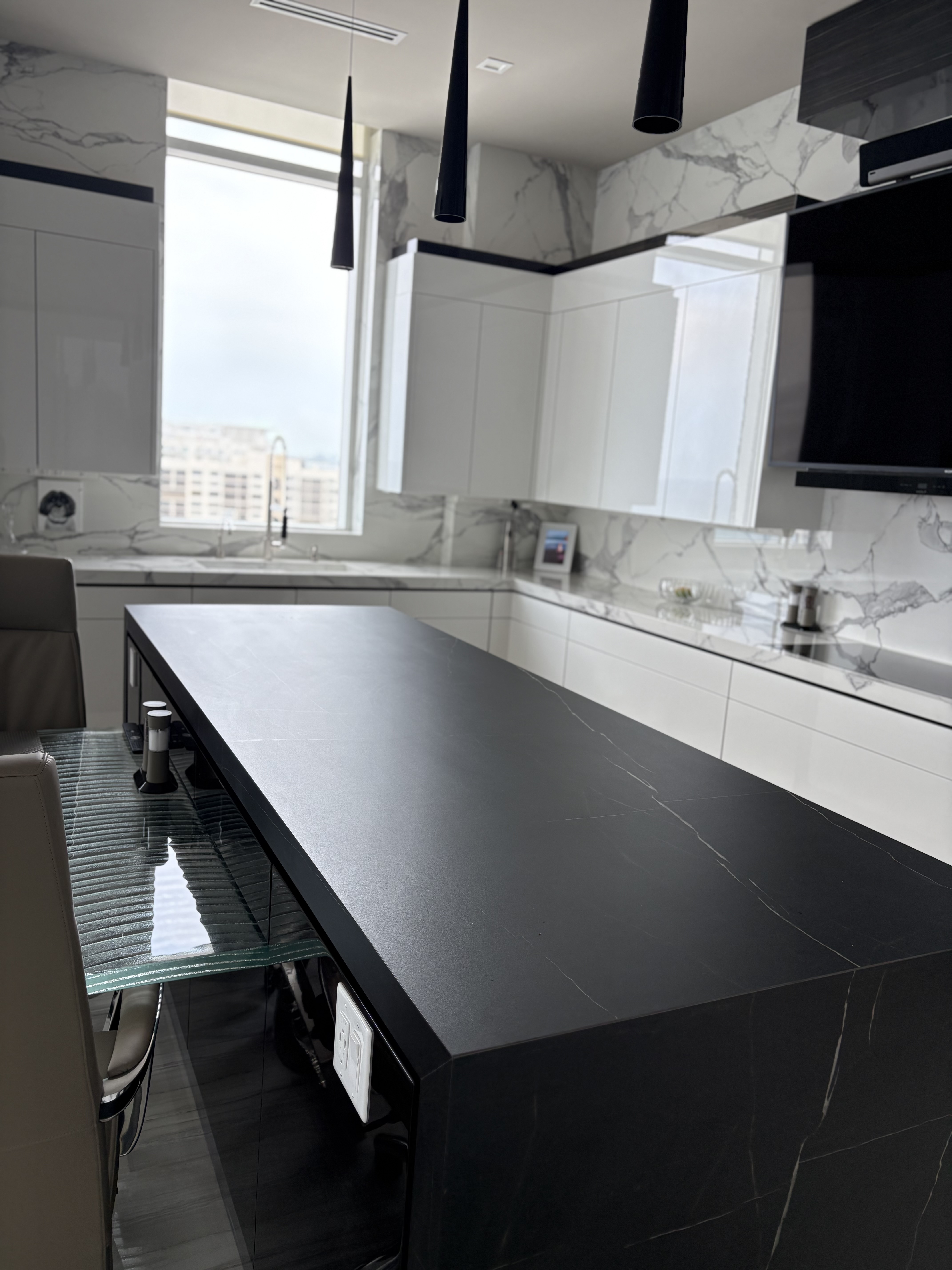 Matte black waterfall island over a fluted glass base