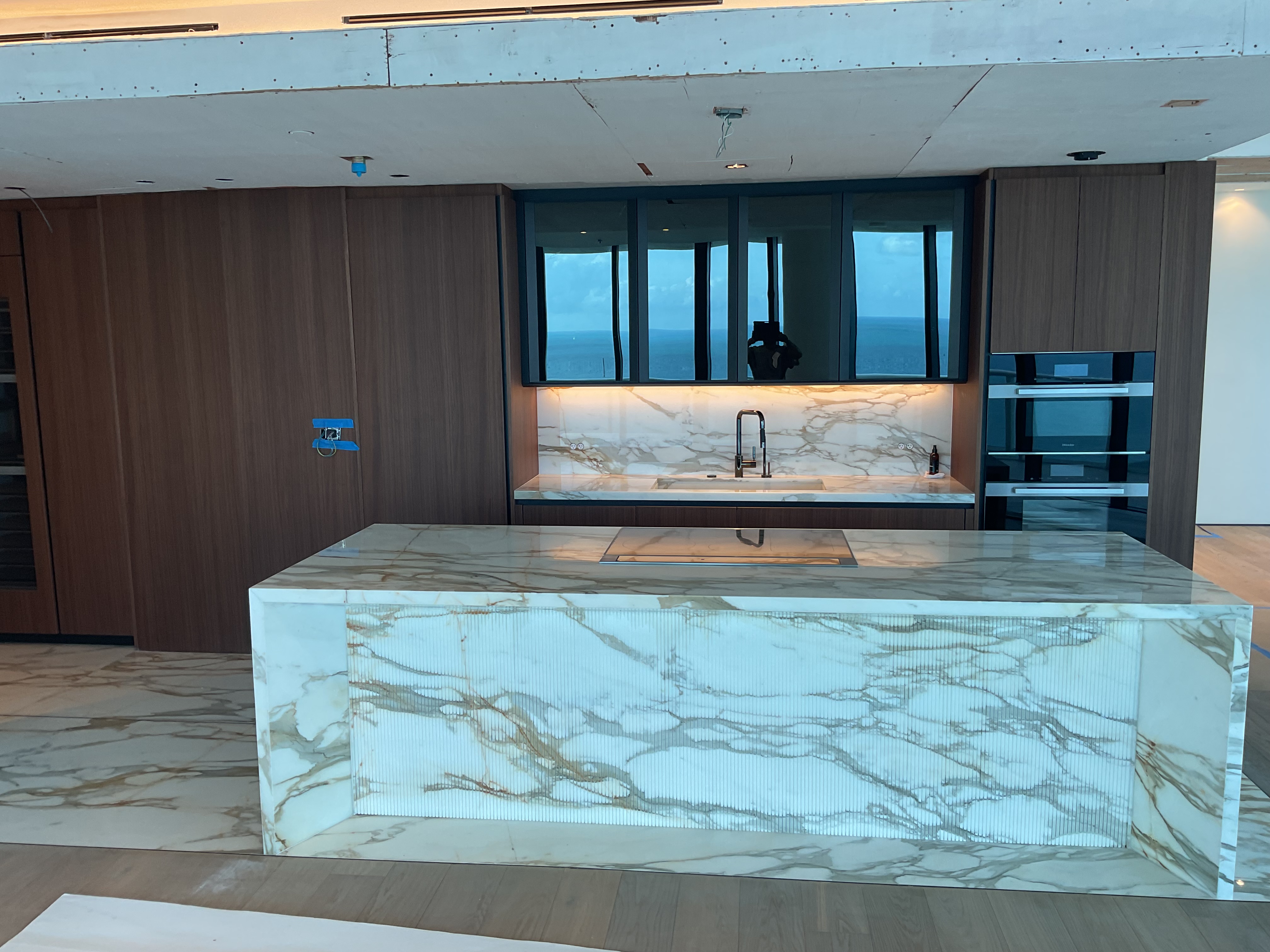 Calacatta gold island with a fluted stone base and ocean view